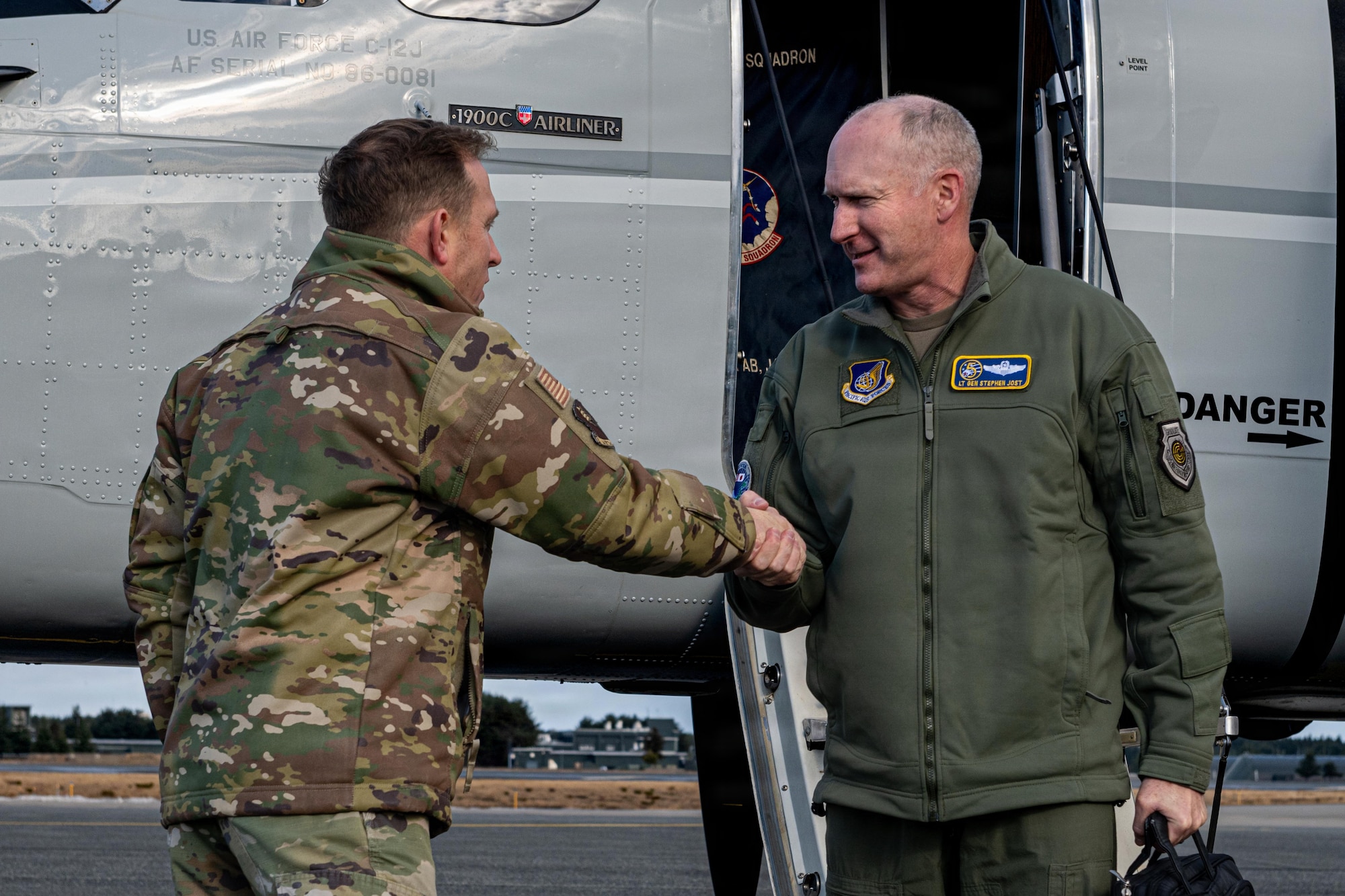 U.S. Air Force Col. Paul Davidson, left, 35th Fighter Wing (FW) commander, shakes hands with Lt. Gen. Stephen Jost, U.S. Forces Japan and Fifth Air Force commander, as he steps off a C-12 Huron.