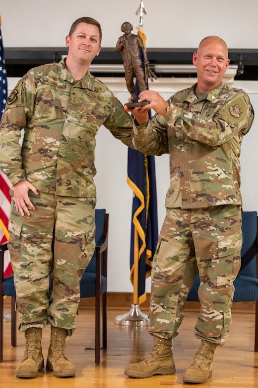 Chief Master Sgt. Patrick Lease, aerial port superintendent for the 123rd Logistics Readiness Squadron, presents Chief Master Sgt. Krome Raymond, senior enlisted leader for the 123rd Mission Support Group, with a token of appreciation during Raymond’s retirement ceremony at the Kentucky Air National Guard Base in Louisville, Ky., Sept. 7, 2025. Raymond served 22 years in both the active-duty Air Force and Kentucky Air Guard during three periods of enlistment spread over 38 years. (U.S. Air National Guard photo by Senior Airman Annaliese Billings)