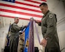 Col. Matthew Quenichet, commander of the 123rd Airlift Wing, pins the unit’s 21st Air and Space Outstanding Unit Award streamer to the wing guidon during a ceremony at the Kentucky Air National Guard Base in Louisville, Ky., Dec. 14, 2025. The new honor, previously known as the Air Force Outstanding Unit Award, continues the unit’s legacy as the most decorated tactical airlift wing in the United States Air Force. (U.S. Air National Guard photo by Master Sgt. Joshua Horton)