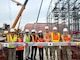 Members from the U.S. Army Corps of Engineers – Japan Engineer District (USACE JED) Yokota Resident Office, pose for a photo with the last structural beam to be installed in the currently-under construction Corrosion Control Hangar, during a Topping Out ceremony, October 3rd, 2025. A topping-out ceremony is a long-standing construction tradition signifying that the final structural beam has been placed atop a building’s frame. The milestone symbolizes progress, safety, and teamwork among the project’s engineers, contractors, and partners as construction moves from heavy structural work into interior and systems installation. Courtesy photo provided by Gilbane Japan.