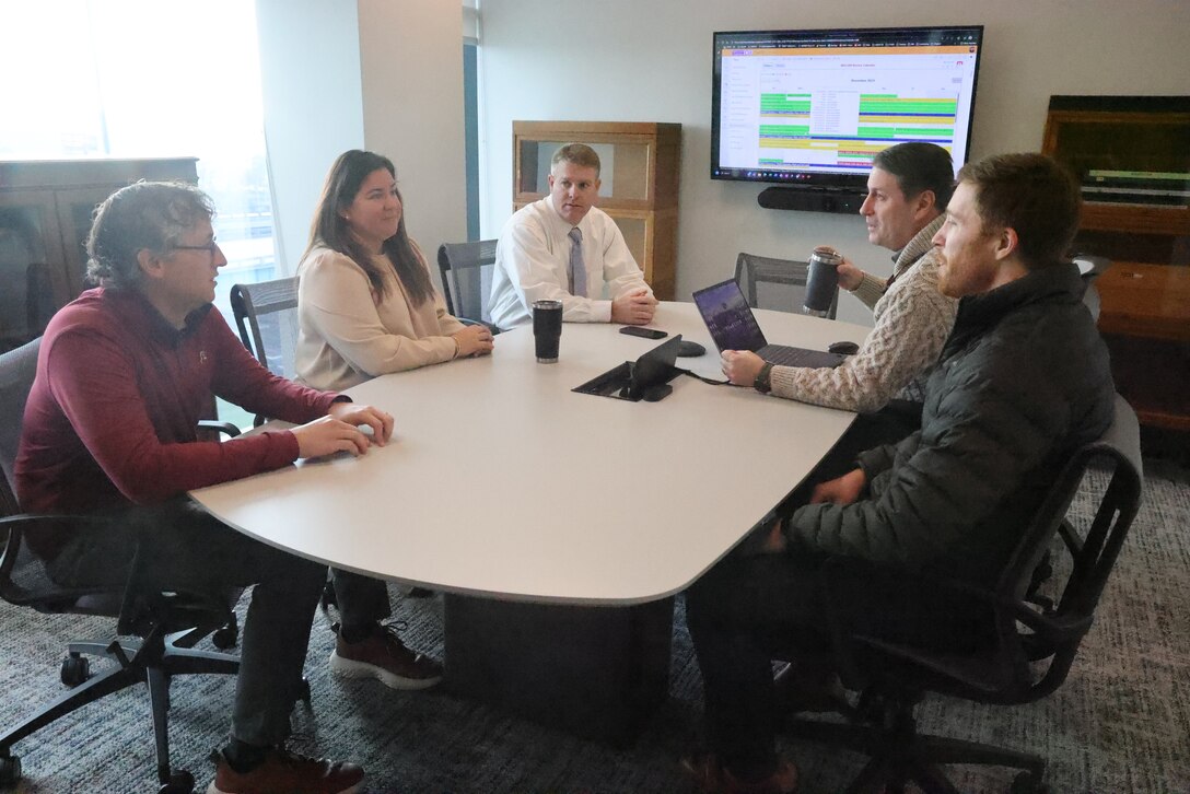 Five people sitting around a table.