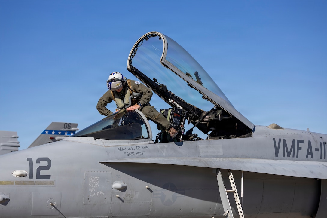 U.S. Marine Corps Maj. Sean Dolan, a pilot with Marine Fighter Attack Squadron (VMFA) 112, Marine Aircraft Group 41, 4th Marine Aircraft Wing, boards an F/A-18C Hornet aircraft in preparation for close air support training at Naval Air Station Joint Reserve Base Fort Worth, Texas, Dec. 9, 2025. The training serves to increase proficiency, validate ordinance handling procedures, and support joint fire support elements. (U.S. Marine Corps photo by Staff Sgt. Ethan M. LeBlanc)