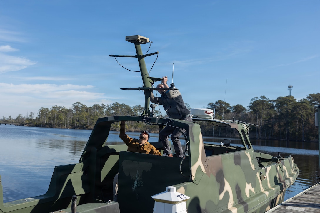 U.S. Department of War contactors prepare a riverine assault support system to mount a SEAFLIR 240-EP maritime surveillance sensor at Marine Corps Base Camp Lejeune, North Carolina, Dec. 10, 2025. 2nd Marine Logistics Group is working with the Marine Corps Warfighting Lab to experiment with the RASS for a more lethal, agile, and resilient capability while conducting expeditionary advanced base operations. (U.S. Marine Corps photo by Sgt. Rafael Brambila-Pelayo)