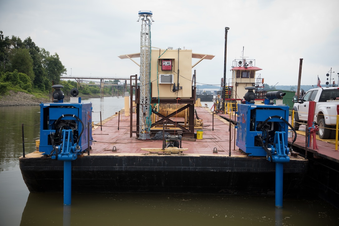 A modified barge docked in a harbor.