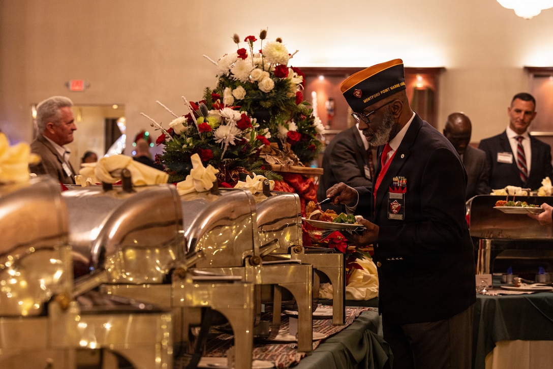 A guest places food on their plate during the 2025 Holiday Buffet and Cocktail Reception at Marine Corps Base Camp Pendleton, California, Dec. 11, 2025. U.S. Marine Corps Brig. Gen. Brown, the commanding general of Marine Corps Installations West, hosted the event to kick off the holiday season and build camaraderie between MCIWEST and its surrounding units and organizations. (U.S. Marine Corps photo by Cpl.  Akamelu)