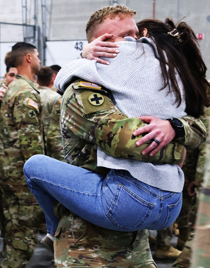 Sydney Weaver jumps into the arms of her husband, Illinois Army National Guard Staff Sgt. Justin Weaver, upon his return from deployment.