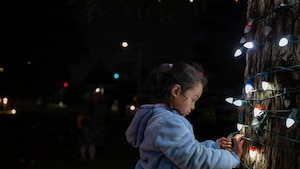 A child admires lights on a Christmas Tree