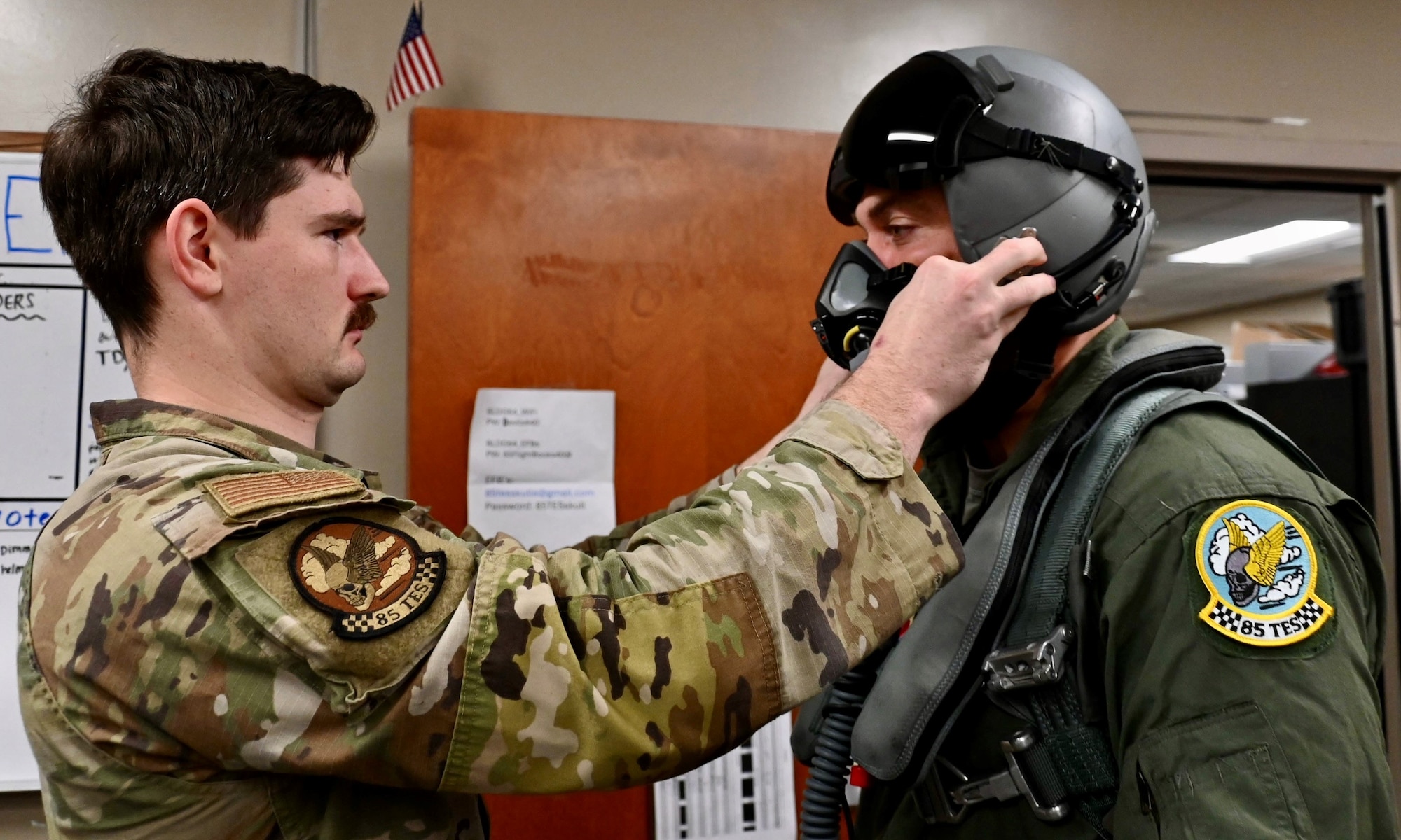 U.S. Air Force  Staff Sgt. Ryan McCabe, 85th Test and Evaluation Squadron, aircrew flight equipment (AFE) craftsman, assists Under Secretary of the Air Force Matt Lohmeier, as he adjusts his helmet in preparation for his F-15EX Eagle II familiarization flight at Eglin Air Force Base, Florida, December 11, 2025. AFE troops manage life-saving gear (helmets, parachutes, masks, survival kits) and ensure its meticulous readiness, directly enabling aircrew survival and mission success by preventing equipment failure, supporting training, and allowing aviators to focus on mission success. (U.S. Air Force photo by Capt. M. Ryan Goss)