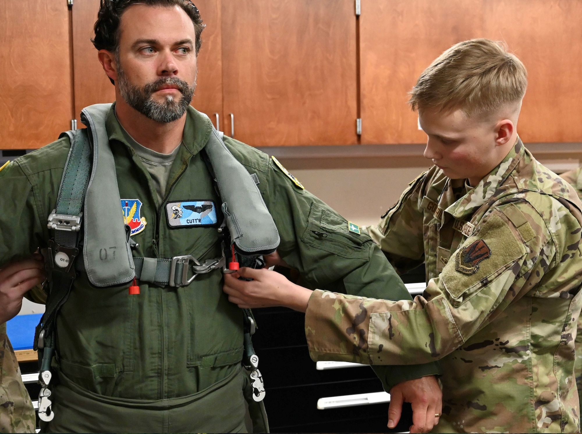 U.S. Air Force Airman Hunter Goodridge, 85th Test and Evaluation Squadron, aircrew flight equipment (AFE) apprentice, assists Under Secretary of the Air Force Matt Lohmeier in preparation for his F-15EX Eagle II familiarization flight at Eglin Air Force Base, Florida, December 11, 2025. AFE troops manage life-saving gear (helmets, parachutes, masks, survival kits) and ensure its meticulous readiness, directly enabling aircrew survival and mission success by preventing equipment failure, supporting training, and allowing aviators to focus on mission success. (U.S. Air Force photo by Capt. M. Ryan Goss)