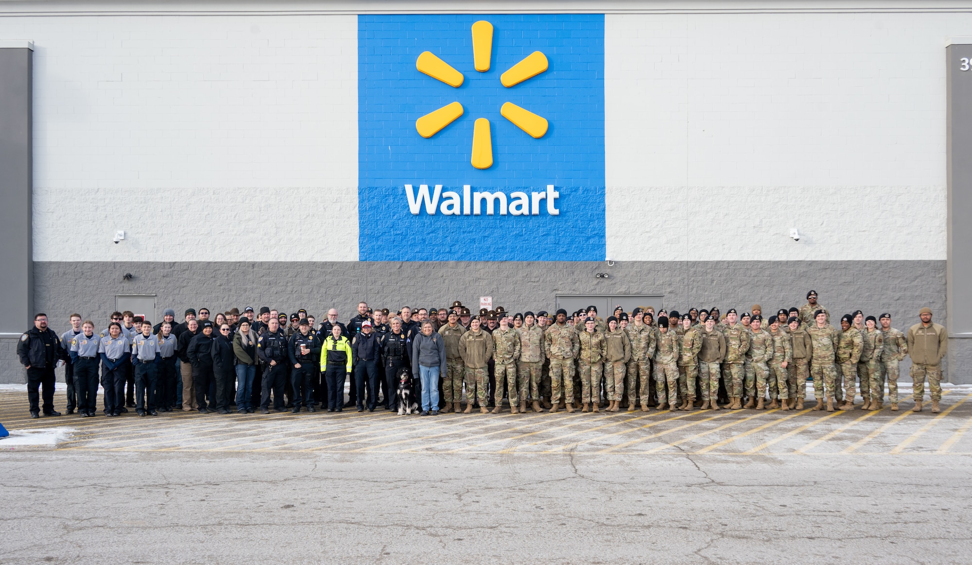 U.S. Air Force Defenders, law enforcement officers and community members pose for a group photo during the annual Cops and Kids event at a Walmart in Minot, North Dakota, Dec. 14, 2025. Service members volunteered their time to assist children while they shopped for holiday gifts as part of a community outreach event. (U.S. Air Force photo by Senior Airman Luis Gomez)