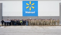 U.S. Air Force Defenders, law enforcement officers and community members pose for a group photo during the annual Cops and Kids event at a Walmart in Minot, North Dakota, Dec. 14, 2025. Service members volunteered their time to assist children while they shopped for holiday gifts as part of a community outreach event. (U.S. Air Force photo by Senior Airman Luis Gomez)