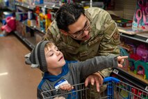 A U.S. Air Force Defender assigned to Minot Air Force Base helps a child pick out toys during the annual Cops and Kids event at Walmart in Minot, North Dakota, Dec. 14, 2025. Service members volunteered their time to assist children while they shopped for holiday gifts as part of a community outreach event. (U.S. Air Force photo by Senior Airman Luis Gomez)