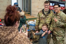 U.S. Air Force Defenders assigned to Minot Air Force Base pose for a photo with a child during the annual Cops and Kids event at a Walmart in Minot, North Dakota, Dec. 14, 2025. The event brought together military members, law enforcement and families to support children in the local community during the holiday season. (U.S. Air Force photo by Senior Airman Luis Gomez)