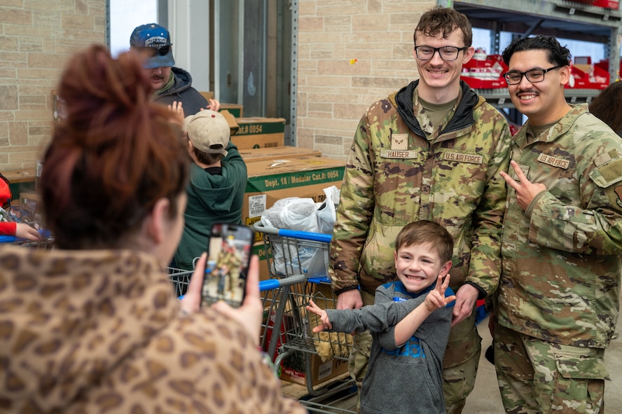 U.S. Air Force Defenders assigned to Minot Air Force Base pose for a photo with a child during the annual Cops and Kids event at a Walmart in Minot, North Dakota, Dec. 14, 2025. The event brought together military members, law enforcement and families to support children in the local community during the holiday season. (U.S. Air Force photo by Senior Airman Luis Gomez)