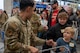 A U.S. Air Force Defender assigned to 791st Missile Security Forces Squadron gives a fist bump to a child during the Cops and Kids event at Walmart in Minot, North Dakota, Dec. 14, 2025. The event paired children with law enforcement officers and military personnel to shop for gifts, thereby strengthening community connections. (U.S. Air Force photo by Senior Airman Luis Gomez)