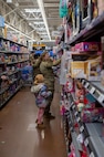 A U.S. Air Force Defender assigned to Minot Air Force Base shops with a child during the annual Cops and Kids event at a Walmart in Minot, North Dakota, Dec. 14, 2025. Cops and Kids provides local children the opportunity to select holiday gifts while building positive relationships with first responders and service members. (U.S. Air Force photo by Senior Airman Luis Gomez)