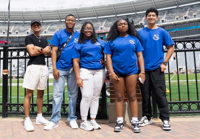 Airman 1st Class Alexia Lassin (middle), a contracting specialist assigned to the 42d Contracting Squadron, pose for a photo with Airmen during a fundraising event at the Alabama State game, on Alabama, Sep. 6, 2025.