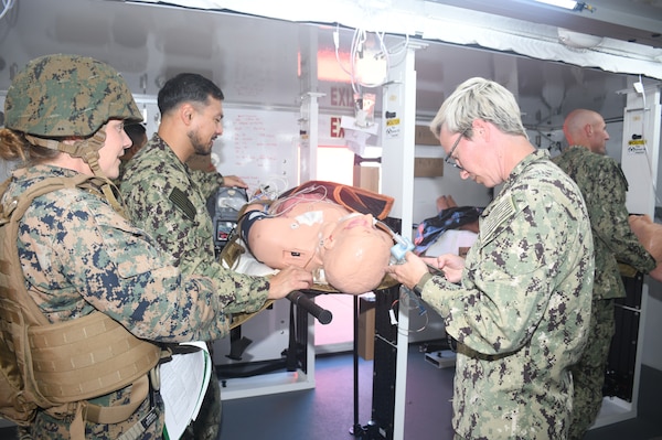 A patient receives continued care inside one of two Rapid Emergency Medical (REM) Pod/Units during a  mass casualty response drill on Naval Air Station North Island.  Members of the Military Sealift Command (MSC) hospital ship USNS Mercy (T-AH 19) Medical Treatment Facility (MTF) along with Marines from the Expeditionary Medical Facility, 4th Marine Medical Battalion and the Marine Corps Warfighting Lab participated in the drill as part of the larger, multi-service exercise, Steel Knight 2025, held at Marine Base Camp Pendleton, and tested the MTF’s ability to triage, treat and transport multiple simulated patients during a crisis.
