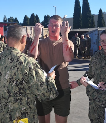 A patient describes his injuries to a doctor in the triage area during a  mass casualty response drill on Naval Air Station North Island.  Members of the Military Sealift Command (MSC) hospital ship USNS Mercy (T-AH 19) Medical Treatment Facility (MTF) along with Marines from the Expeditionary Medical Facility, 4th Marine Medical Battalion and the Marine Corps Warfighting Lab participated in the drill as part of the larger, multi-service exercise, Steel Knight 2025, held at Marine Base Camp Pendleton, and tested the MTF’s ability to triage, treat and transport multiple simulated patients during a crisis.