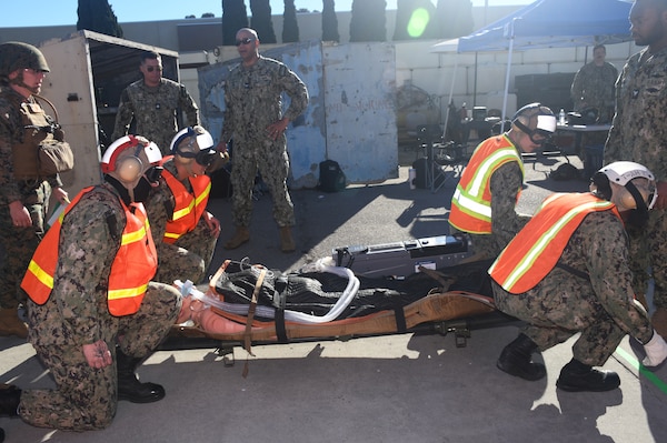 Navy aircrewmen deliver a patient to the triage area during a mass casualty response drill on Naval Air Station North Island.  Members of the Military Sealift Command (MSC) hospital ship USNS Mercy (T-AH 19) Medical Treatment Facility (MTF) along with Marines from the Expeditionary Medical Facility, 4th Marine Medical Battalion and the Marine Corps Warfighting Lab participated in the drill as part of the larger, multi-service exercise, Steel Knight 2025, held at Marine Base Camp Pendleton, and tested the MTF’s ability to triage, treat and transport multiple simulated patients during a crisis.