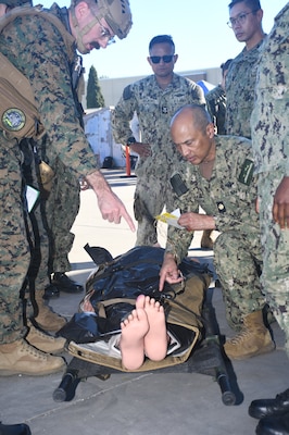 A doctor assesses a patient in the triage area during a  mass casualty response drill on Naval Air Station North Island.  Members of the Military Sealift Command (MSC) hospital ship USNS Mercy (T-AH 19) Medical Treatment Facility (MTF) along with Marines from the Expeditionary Medical Facility, 4th Marine Medical Battalion and the Marine Corps Warfighting Lab participated in the drill as part of the larger, multi-service exercise, Steel Knight 2025, held at Marine Base Camp Pendleton, and tested the MTF’s ability to triage, treat and transport multiple simulated patients during a crisis.