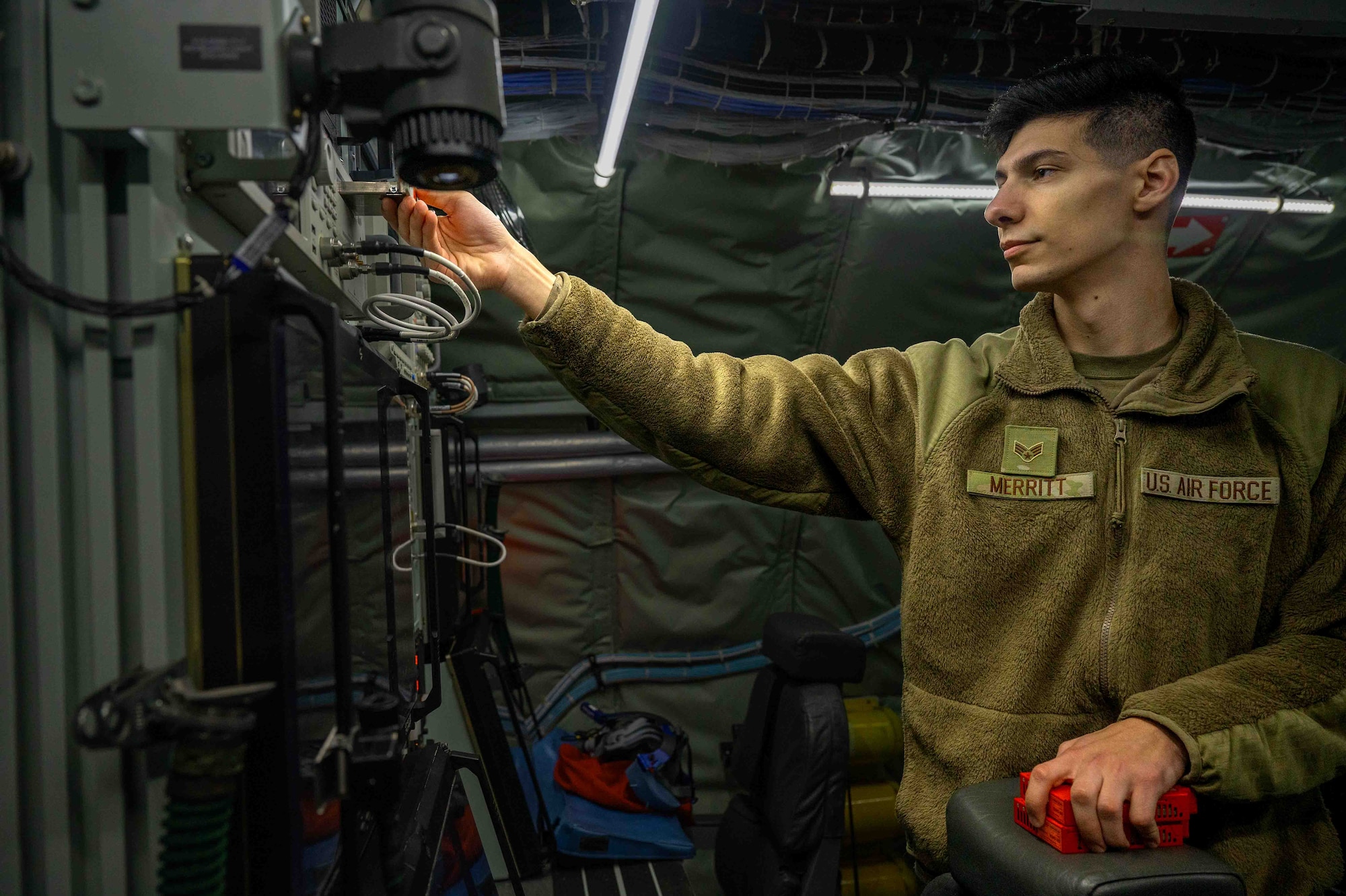 U.S. Air Force Senior Airman Tristan Merritt, 82nd Reconnaissance Squadron electronic warfare journeyman, installs a solid-state drive into an RC-135V/W Rivet Joint at Kadena Air Base, Japan, Feb. 18, 2025.