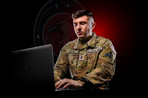 U.S. Space Force 1st Lt. Nickolas Violissi poses for a photo with a laptop computer.