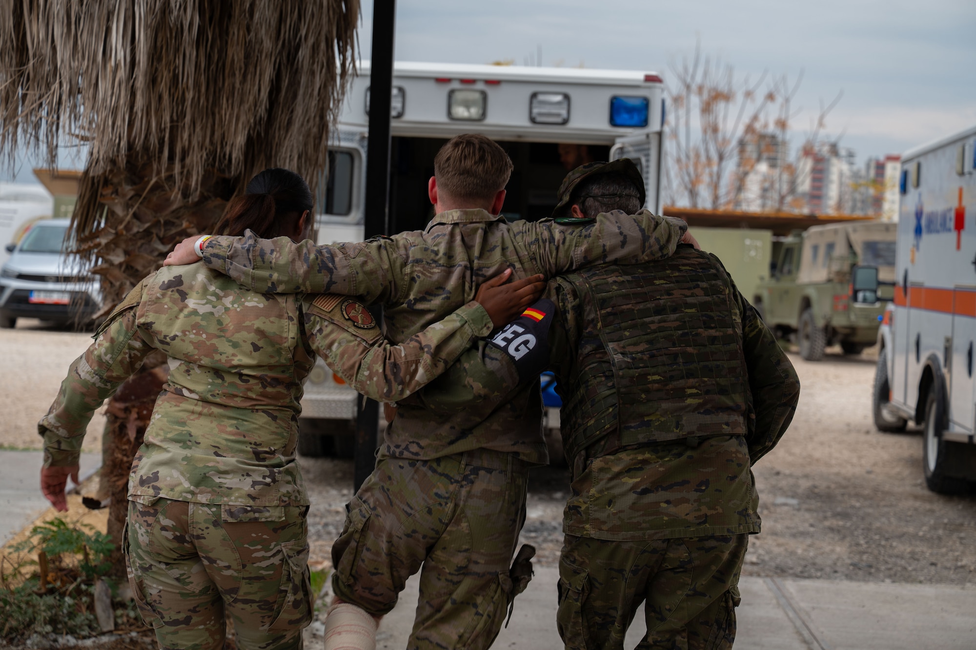 Members of the US. Air Force and Spanish Army members transport simulated victim to ambulance.