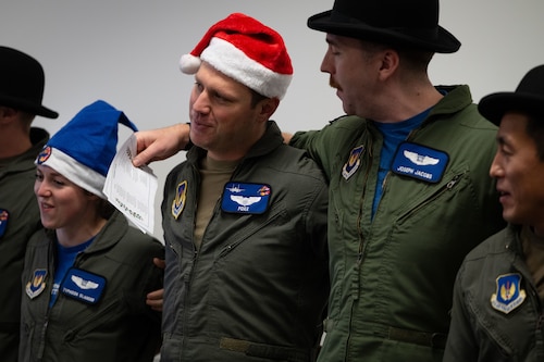 Members of the 492nd Fighter Squadron sing Christmas carols at the Imperial War Museum Duxford, Cambridge, England.