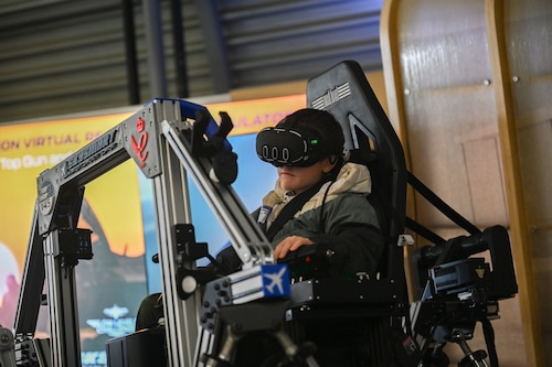 A photo of a child in a flight simulator.