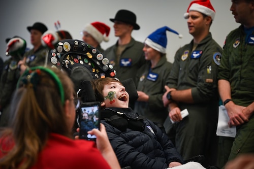 Members of the 492nd Fighter Squadron sing Christmas carols to kids from the East Anglia Children’s Hospice at the Imperial War Museum Duxford, Cambridge, England.