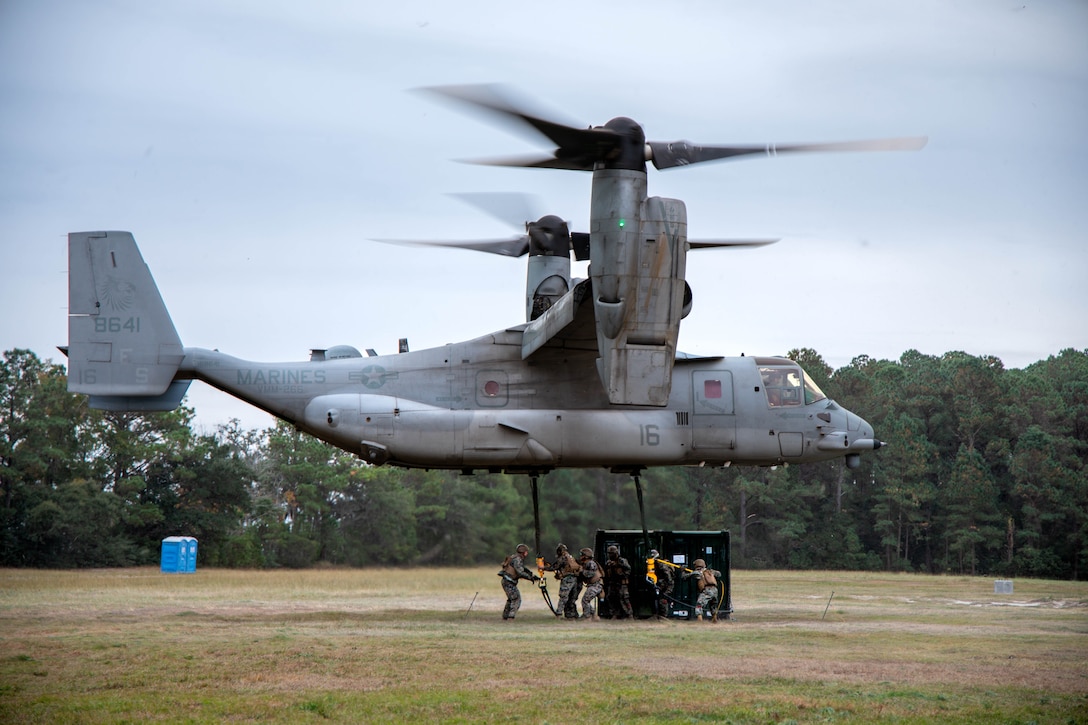 U.S. Marines with Combat Logistics Battalion (CLB) 8, 24th Marine Expeditionary Unit (MEU), prepare to sling load a quadruple container onto an MV-22B Osprey assigned to Marine Medium Tiltrotor Squadron (VMM) 266, II Marine Aircraft Wing, during helicopter support team operations at Marine Corps Base Camp Lejeune, North Carolina, Nov. 25, 2025. The 24th MEU is a Marine Air Ground Task Force ready to answer our Nation's call in any clime and place. (U.S. Marine Corps Photo taken by Cpl. Daniel Childs)