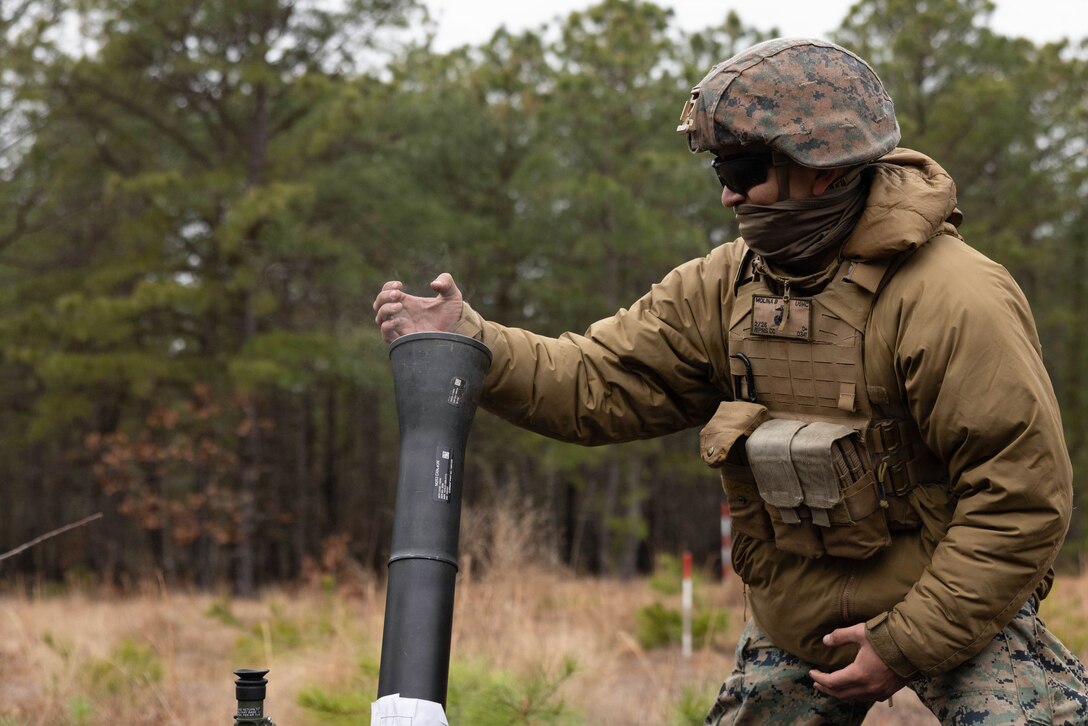 U.S. Marine Corps Lance Cpl. Brandon Molina, a mortarman, demonstrates proper technique for firing an 81mm mortar round at Joint Base McGuire-Dix-Lakehurst, New Jersey, Dec. 6, 2025. Molina, a mortarman with 2nd Battalion, 25th Marine Regiment, 4th Marine Division, participates in live-fire drills designed to improve tactical decision-making, leadership, and technical skills while ensuring readiness for future missions. (U.S. Marine Corps photo by Lance Cpl. Breysson Villacortacampos)