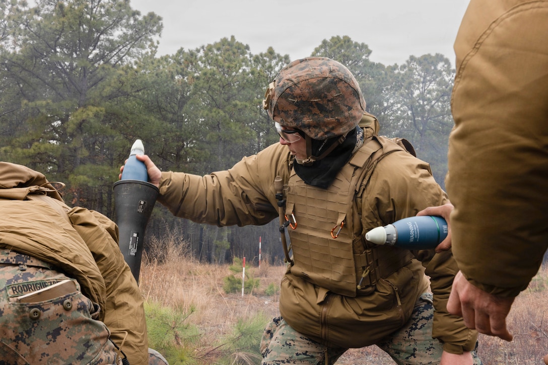 U.S. Marine Corps Lance Cpl. Samuel Tomlinson, a mortarman, prepares to fire an 81mm practice round using an M252A2 81mm Medium Extended Range Mortar System at Joint Base McGuire-Dix-Lakehurst, New Jersey, Dec. 6, 2025. Tomlinson, with 2nd Battalion, 25th Marine Regiment, 4th Marine Division, maintains readiness through drills and training that build confidence and develop future leaders. (U.S. Marine Corps photo by Lance Cpl. Breysson Villacortacampos)