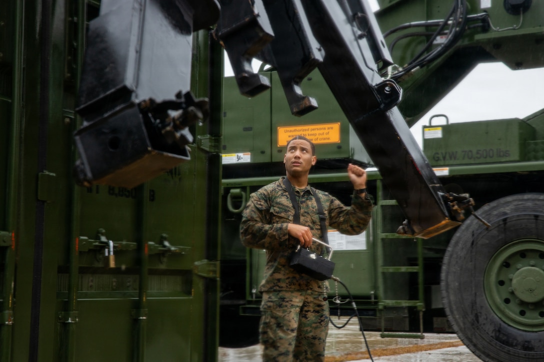 U.S. Marine Corps Lance Cpl. Bryan Salvadorgonzalez, a motor vehicle operator with II Marine Expeditionary Force Support Battalion, II MEF Information Group, guides a Logistic Vehicle System Replacement at Marine Corps Base Camp Lejeune, North Carolina, Dec. 5, 2025. Marines with II MEF Support Battalion then loaded the equipment in preparation for missions, honing their skills while showcasing the unit’s capabilities to prepare for onward movement at a moment’s notice. (U.S. Marine Corps photo by Cpl. Jack Labrador)