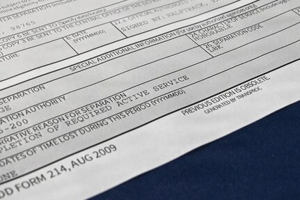A close-up view of the bottom of a mock service member's separation from DD-214 is shown with the word "honorable" written in the characterization of service block.