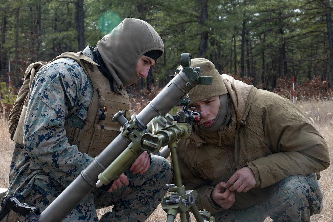 U.S. Marine Corps Lance Cpl. Samuel Tomlinson and Cpl. Emmanuel Familia, both mortarmen, set the sights on an M252A2 60 mm mortar system as they prepare for a live-fire exercise at Joint Base McGuire-Dix-Lakehurst, New Jersey, Dec. 5, 2025. These Marines from 2nd Battalion, 25th Marine Regiment, 4th Marine Division, conduct live-fire drills to enhance tactical decision-making, leadership, and technical proficiency during the training event. The exercise supports ongoing efforts to sustain combat readiness and reinforce core infantry skills across the battalion. ((U.S. Marine Corps photo by Lance Cpl. Breysson Villacortacampos)