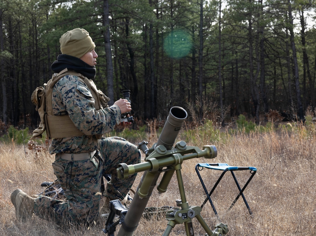 U.S. Marine Corps Pfc. Christoffer Herrera Meneses, a mortarman, kneels beside an M252A2 60 mm mortar system as he prepares for a live-fire exercise at Joint Base McGuire-Dix-Lakehurst, New Jersey, Dec. 5, 2025. Meneses, a Marine with 2nd Battalion, 25th Marine Regiment, 4th Marine Division, conducts live-fire drills to enhance tactical decision-making, leadership and technical proficiency during the training event. The exercise supports ongoing efforts to sustain combat readiness and reinforce core infantry skills across the battalion.