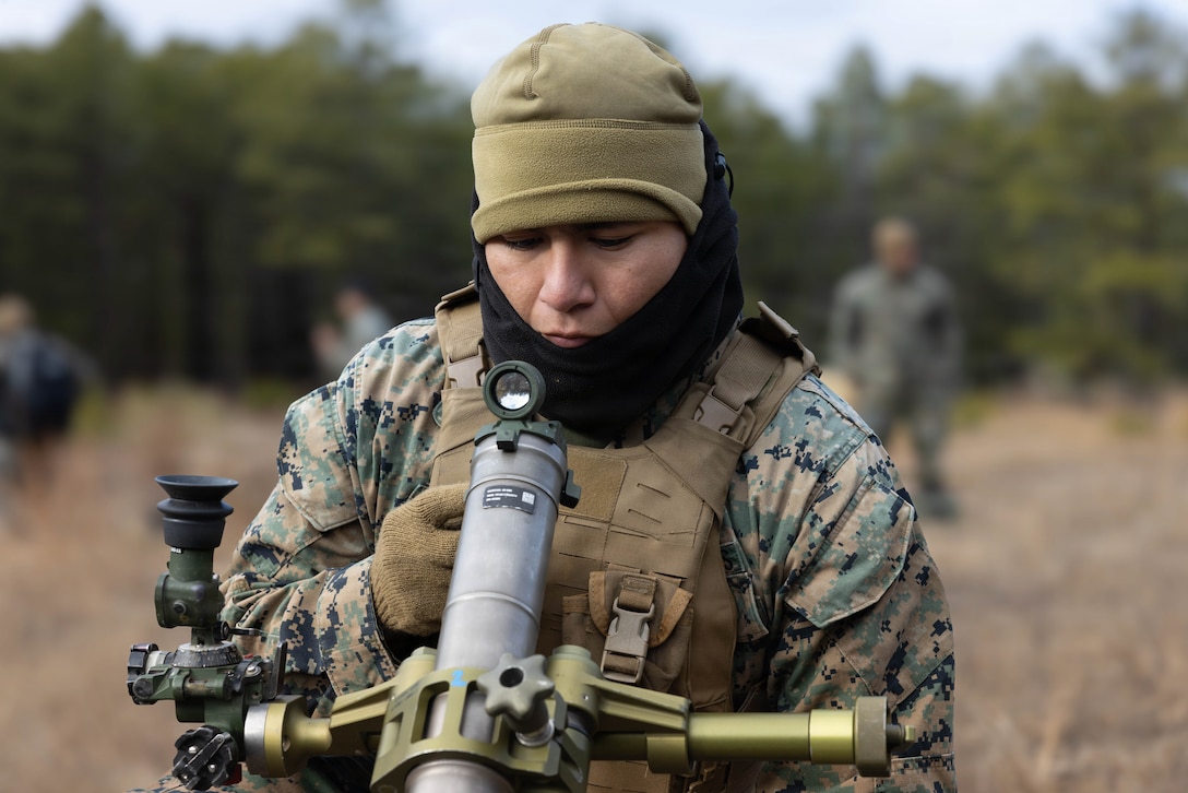 U.S. Marine Corps Pfc. Christoffer Herrera Meneses, a mortarman, adjusts the bore sighting on a M252A2 60mm mortar system as he prepares for a live-fire exercise at Joint Base McGuire-Dix-Lakehurst, New Jersey, Dec. 5, 2025. Meneses, a Marine with 2nd Battalion, 25th Marine Regiment, 4th Marine Division, conducts live-fire drills to enhance tactical decision-making, leadership, and technical proficiency during the training event. The exercise supports ongoing efforts to sustain combat readiness and reinforce core infantry skills across the battalion. (U.S. Marine Corps photo by Lance Cpl. Breysson Villacortacampos)