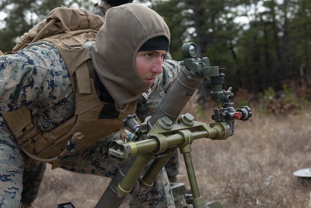U.S. Marine Corps Lance Cpl. Samuel Tomlinson, a mortarman, uses hand and arm signals to align a M252A2 60 mm mortar system as he prepares for a live-fire exercise at Joint Base McGuire-Dix-Lakehurst, New Jersey, Dec. 5, 2025. Tomlinson, a Marine with 2nd Battalion, 25th Marine Regiment, 4th Marine Division, conducts live-fire drills to enhance tactical decision-making, leadership, and technical proficiency during the training event. The exercise supports ongoing efforts to sustain combat readiness and reinforce core infantry skills across the battalion. (U.S. Marine Corps photo by Lance Cpl. Breysson Villacortacampos)