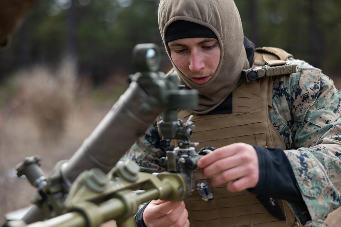 U.S. Marine Corps Lance Cpl. Samuel Tomlinson, a mortarman, adjust the dials on a M252A2 60 mm mortar system as he prepares for a live-fire exercise at Joint Base McGuire-Dix-Lakehurst, New Jersey, Dec. 5, 2025. Tomlinson, a Marine with 2nd Battalion, 25th Marine Regiment, 4th Marine Division, conducts live-fire drills to enhance tactical decision-making, leadership, and technical proficiency during the training event. The exercise supports ongoing efforts to sustain combat readiness and reinforce core infantry skills across the battalion. (U.S. Marine Corps photo by Lance Cpl. Breysson Villacortacampos)