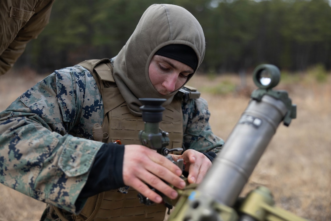 U.S. Marine Corps Lance Cpl. Samuel Tomlinson, a mortarman, sets the sights on a M252A2 60 mm mortar system as he prepares for a live-fire exercise at Joint Base McGuire-Dix-Lakehurst, New Jersey, Dec. 5, 2025. Tomlinson, a Marine with 2nd Battalion, 25th Marine Regiment, 4th Marine Division, conducts live-fire drills to enhance tactical decision-making, leadership, and technical proficiency during the training event. The exercise supports ongoing efforts to sustain combat readiness and reinforce core infantry skills across the battalion. ((U.S. Marine Corps photo by Lance Cpl. Breysson Villacortacampos)