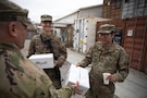 U.S. Army Sgt. Maj. Chad Fischer, operations sergeant major for 2nd Brigade Combat Team, 34th Infantry Division, Iowa National Guard, hands packages from Operation Gratitude to two U.S. Army Soldiers in front of Logistics Support Area Danger’s Post Exchange located in Erbil Air Base, Iraq, Dec. 14, 2025. Operation Gratitude is a nonprofit organization dedicated to honoring the service of service members by creating opportunities for Americans to express gratitude. (U.S. Army Photo by Pfc. Jordan Foster)