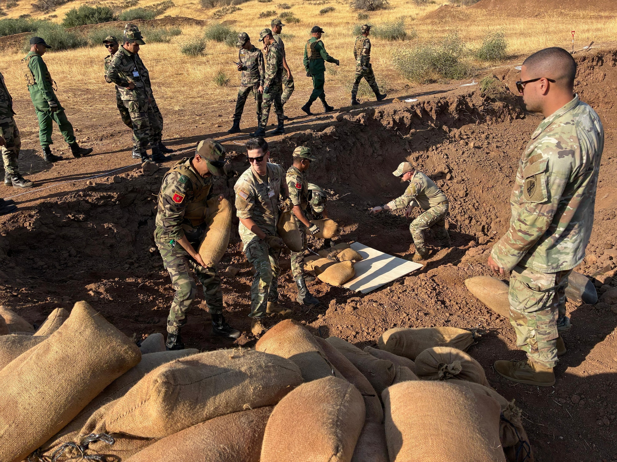 U.S. Air Force explosive ordnance disposal technicians assigned to the 6th Air Refueling Wing and U.S. Army explosive ordnance disposal technicians assigned to the 761st Ordinance Company, demonstrate safe demining techniques to members of the Royal Moroccan Armed Forces during a Humanitarian Mine Action (HMA) mission in Maaziz, Morocco, Aug. 27, 2025. The HMA program is a U.S.-led effort to train partner nations in explosive ordnance disposal. The training enhances EOD capabilities and supports ongoing international efforts to reduce the threat of unexploded ordnance to local communities. (U.S. Air Force courtesy photo)