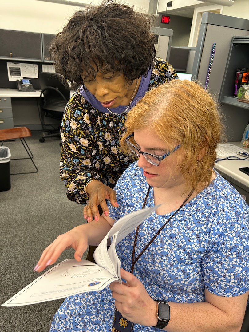 Two women looking at documents.
