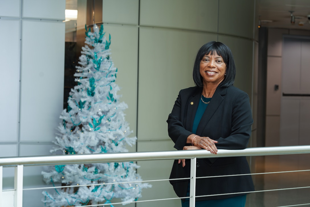 Woman standing at railing.