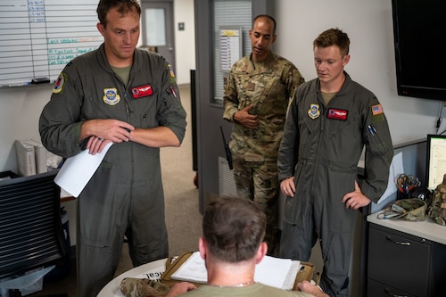 Aircrew assigned to the 50th Air Refueling Squadron discuss flight details with 6th Aircraft Maintenance Squadron debrief specialists at MacDill Air Force Base, Florida, Sept. 17, 2025. Debrief specialists are responsible for collecting, analyzing and communicating flight information between aircrew and maintenance personnel. On any given day, debrief members may contact up to 20 different agencies across the installation to ensure the most accurate, timely information  is communicated to stakeholders. (U.S. Air Force photo by Senior Airman Zachary Foster)