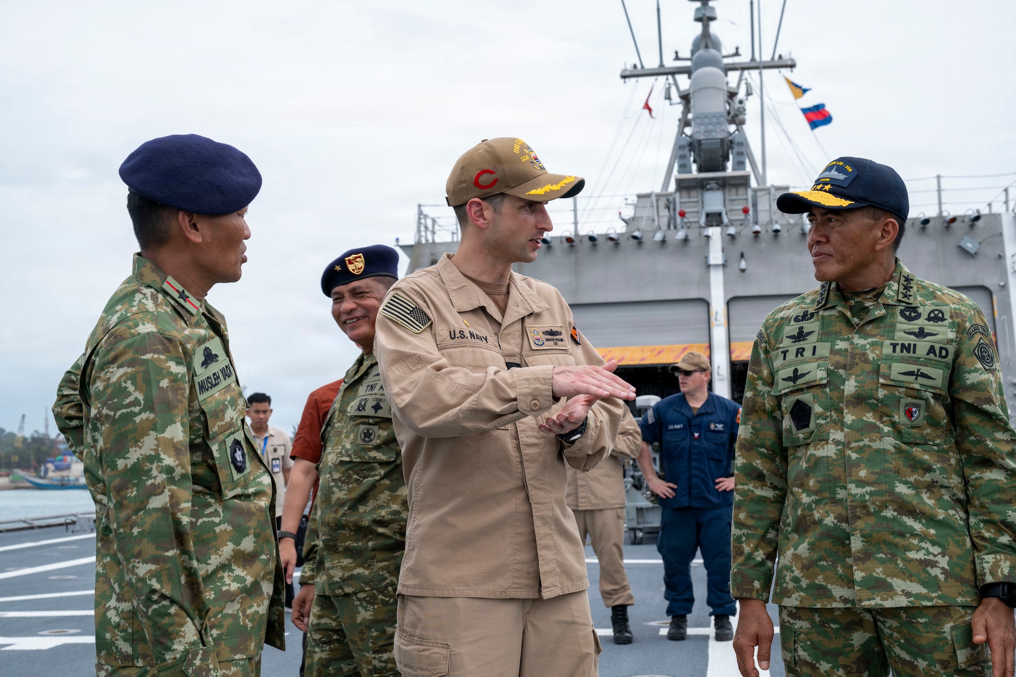 U.S. Navy Cmdr. Andrew Recame, center, commanding officer of Independence-variant littoral combat ship USS Cincinnati (LCS 20), speaks to Indonesian National Armed Forces Lieutenant General Tri Budi Utomo, right, Secretary General, Ministry of Defense, aboard Cincinnati during the Association of Southeast Asian Nations (ASEAN)-U.S. Maritime Exercise (AUMX) 2025, in Batam, Indonesia, Dec. 10, 2025. This is the second iteration of AUMX, designed to promote shared commitments to maritime partnerships, security, and stability in Southeast Asia.  (U.S. Navy photo by Mass Communication Specialist 2nd Class Anthony Robledo)