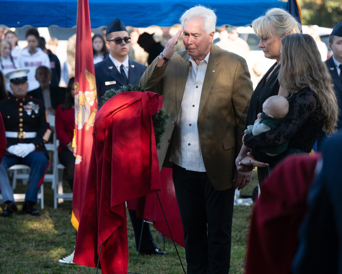 A Gold Star Family stands around a wreath during the Wreaths Across America Placement Ceremony.