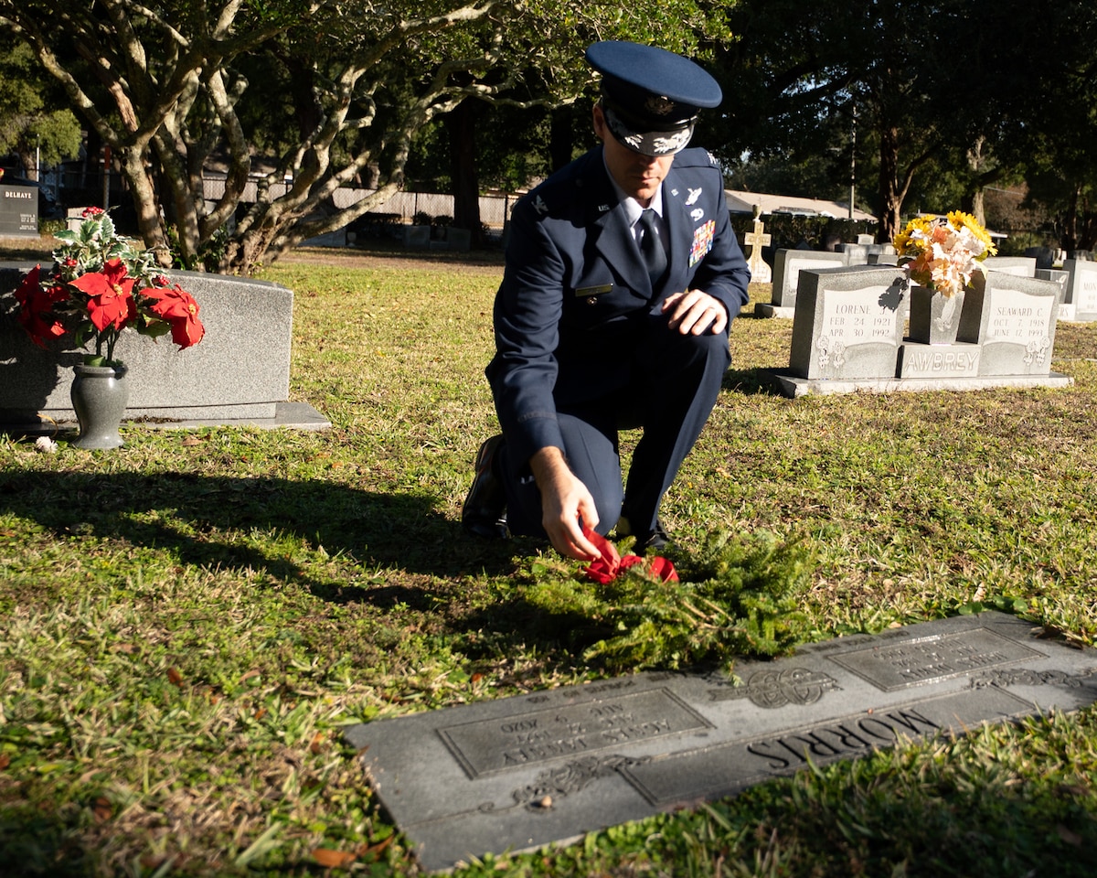 96th Test Wing deputy commander, lays a wreath by a gravestone memorial.